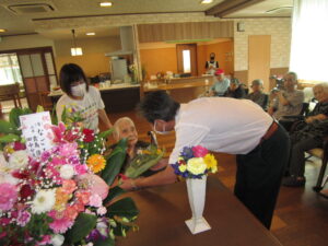 入居者と職員がお花の活動を楽しむ様子。生け花やアレンジメントのレク風景。